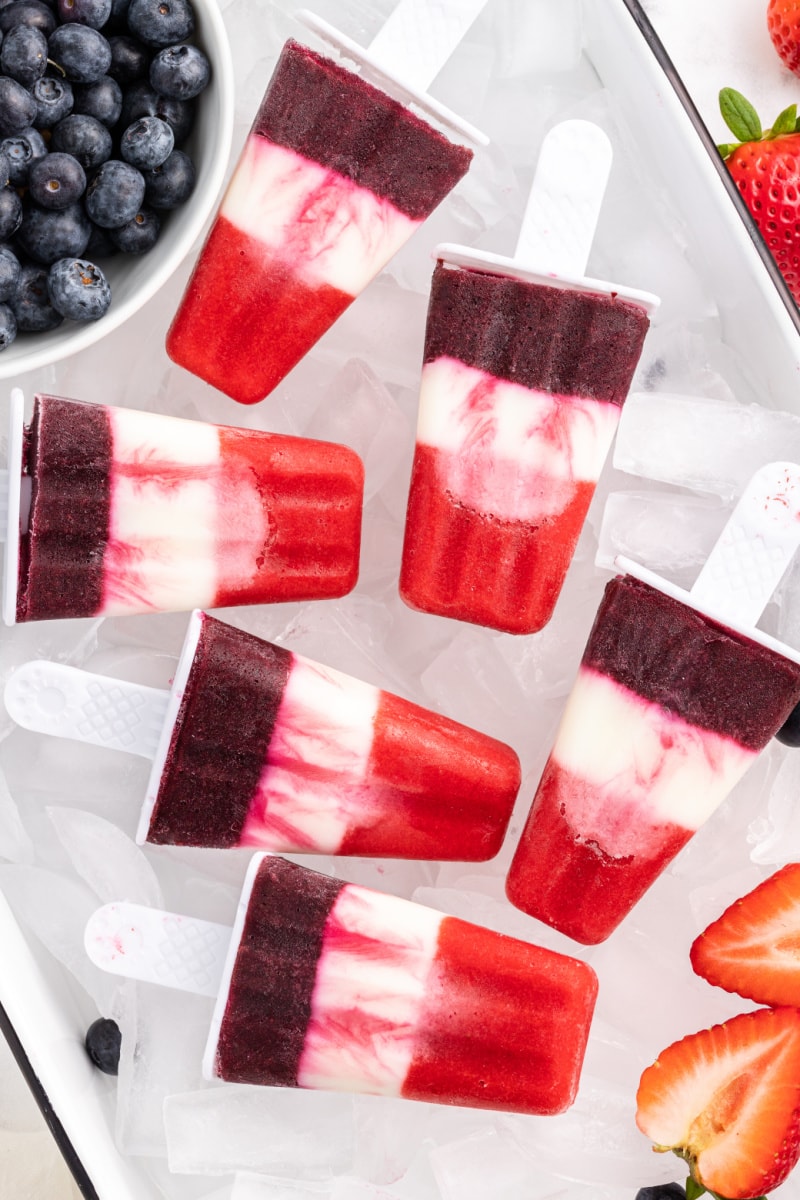 red white and blueberry popsicles over ice