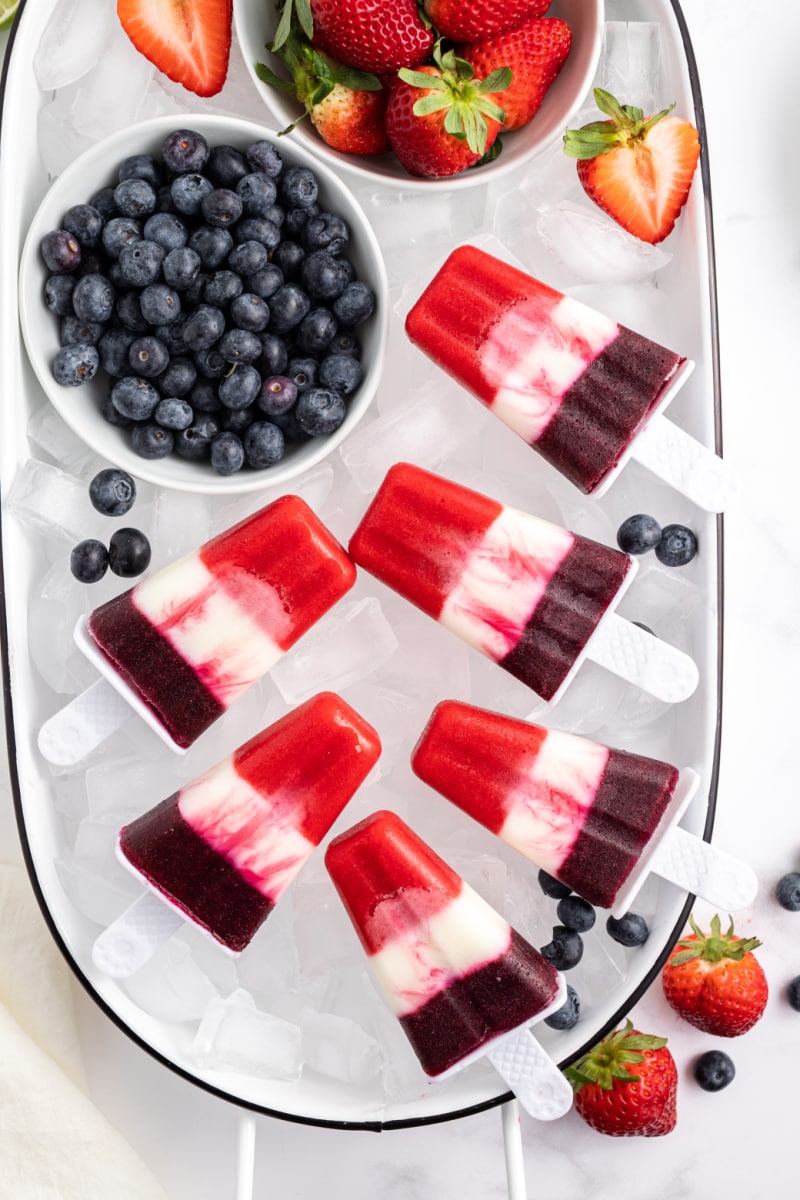 red white and blueberry popsicles on ice with fresh blueberries in bowl