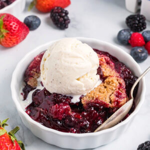 berry crumble in a dish with ice cream