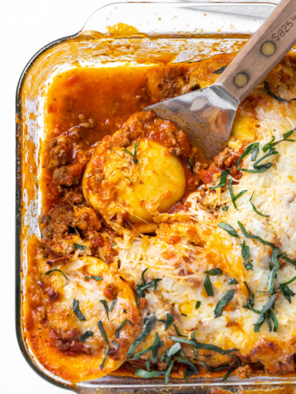 spooning ravioli lasagna out of a dish