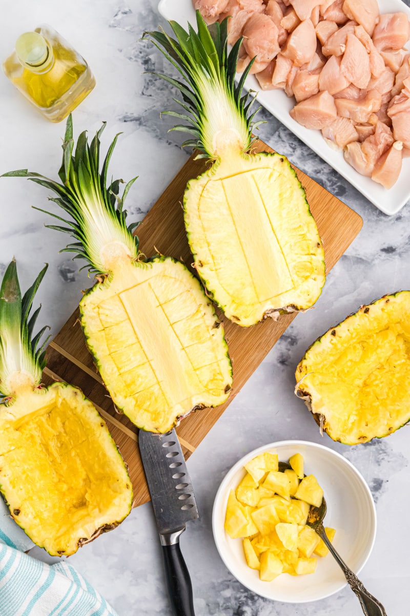 cutting pineapple on a cutting board