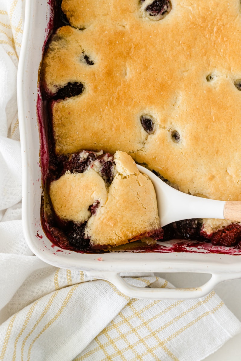 spooning out blackberry raspberry cobbler out of dish