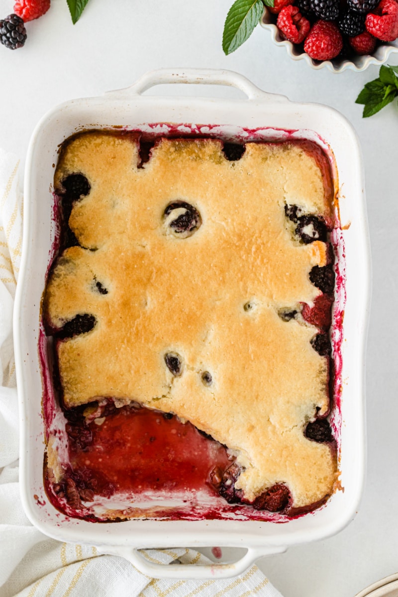 blackberry raspberry cobbler in baking dish with piece taken out of it