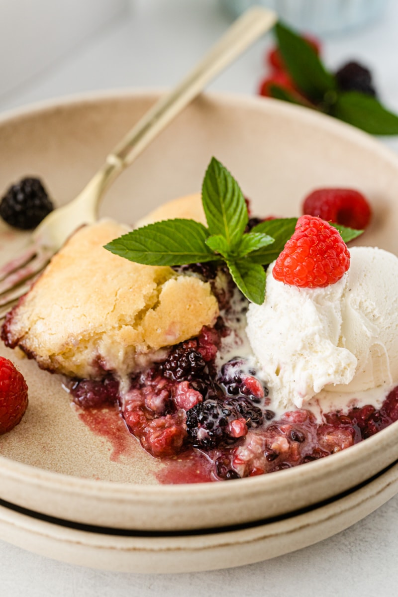 serving of berry cobbler on a plate with whipped cream