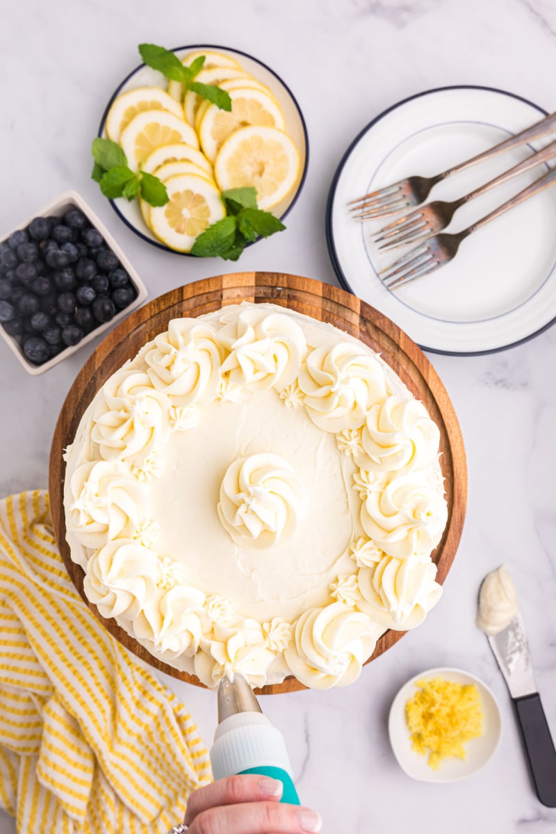 Blueberry Cheesecake Cake recipe from RecipeGirl.com #lemon #blueberry #cheesecake #cake #recipe #RecipeGirl overhead shot of frosted cake