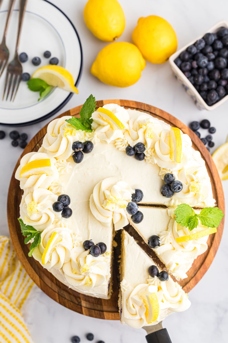 overhead shot of blueberry cheesecake cake with a couple of slices cut