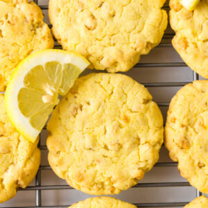 lemon cake mix cookies on a cooling rack with fresh lemon wedges