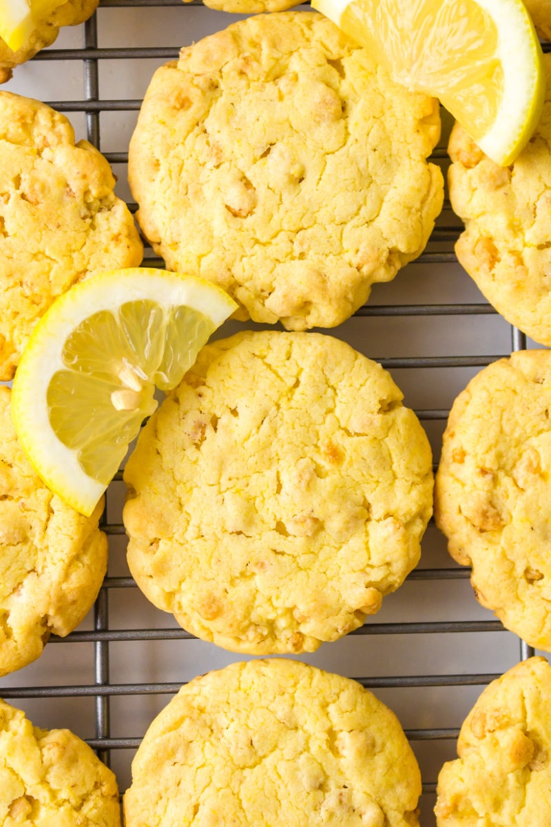 lemon cake mix cookies on a cooling rack with fresh lemon wedges