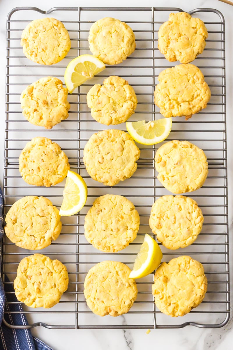lemon cake mix cookies on a cooling rack with lemon wedges