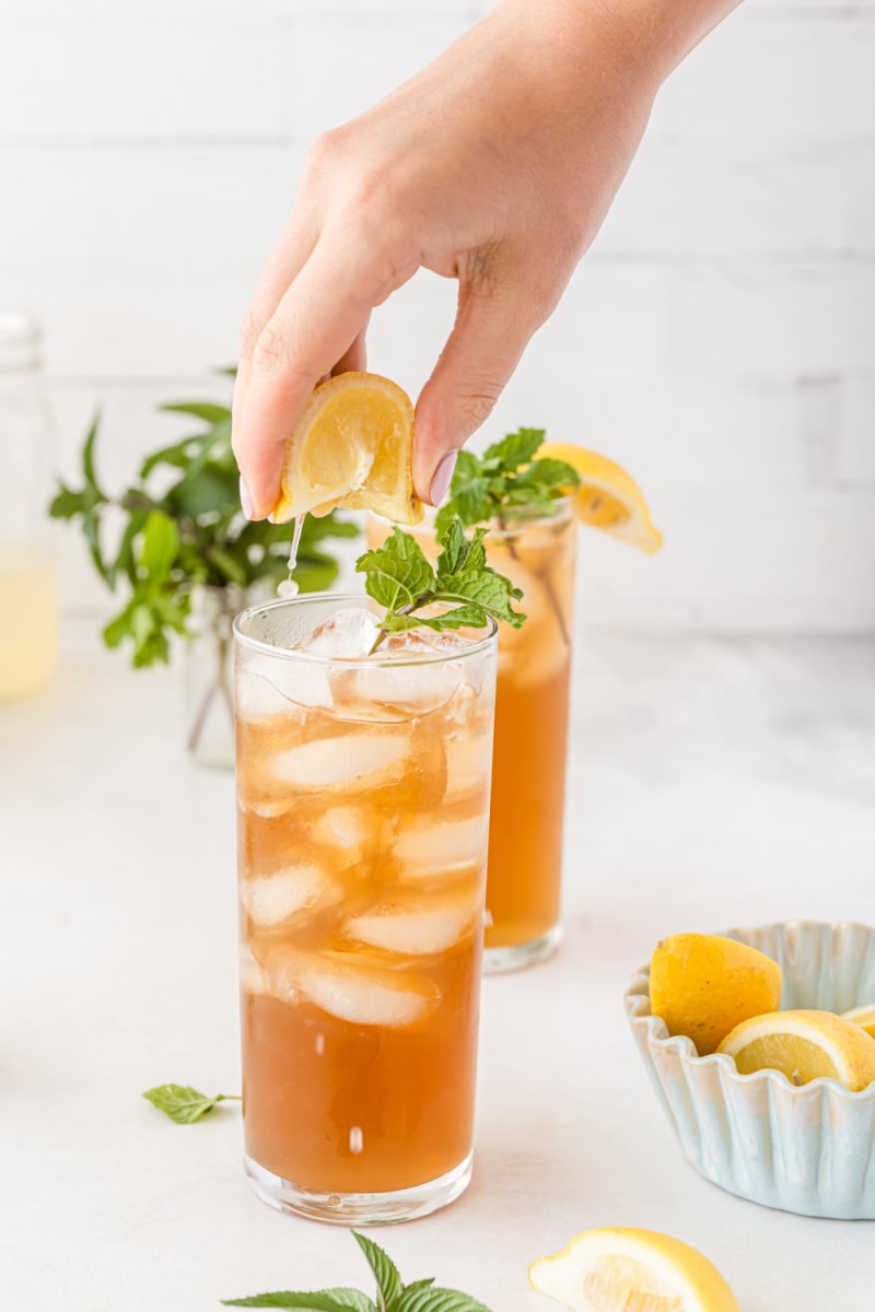 squeezing lemon into cocktail