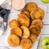 fried green tomatoes on a platter with jar of remoulade sauce