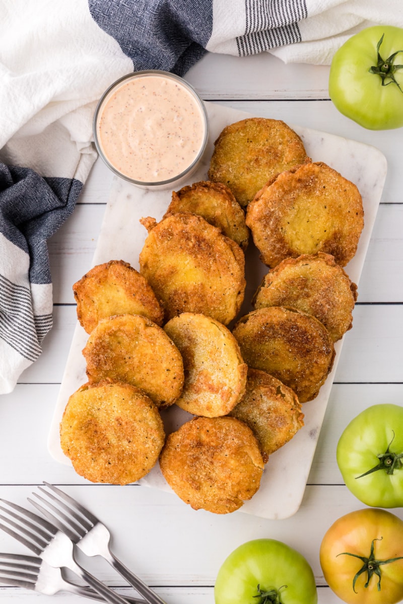fried green tomatoes on a platter with jar of remoulade sauce