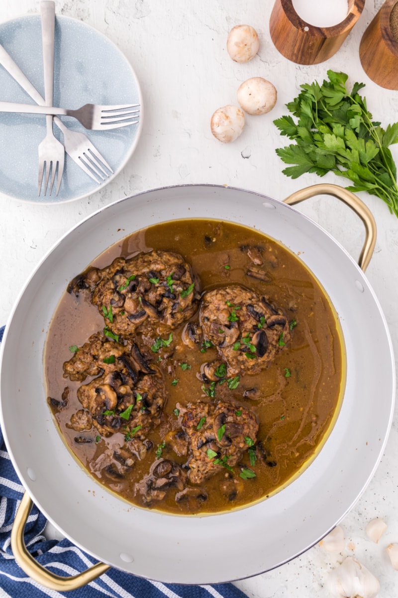 salisbury steak in a skillet with mushroom gray