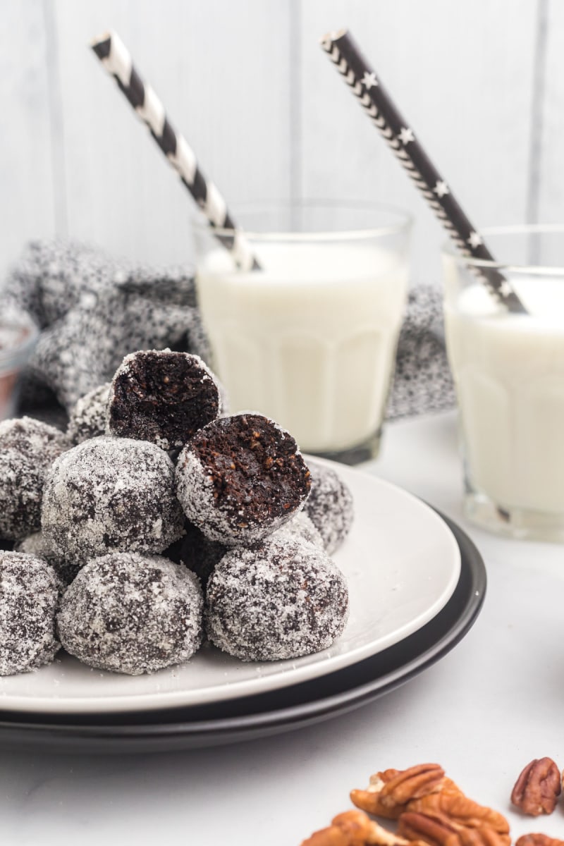 bourbon balls on plate one cut open glasses of milk with straws in background