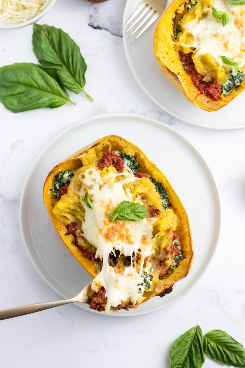 fork pulling away cheese in spaghetti squash lasagna boat