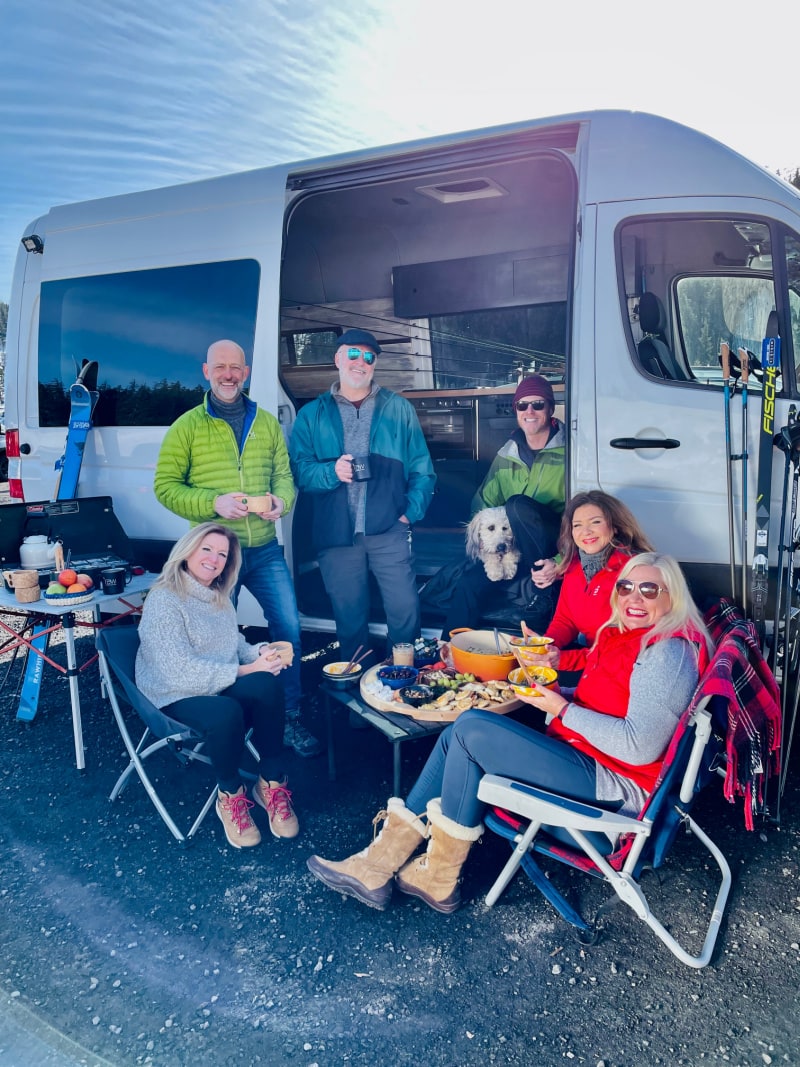 group of people in front of sprinter van