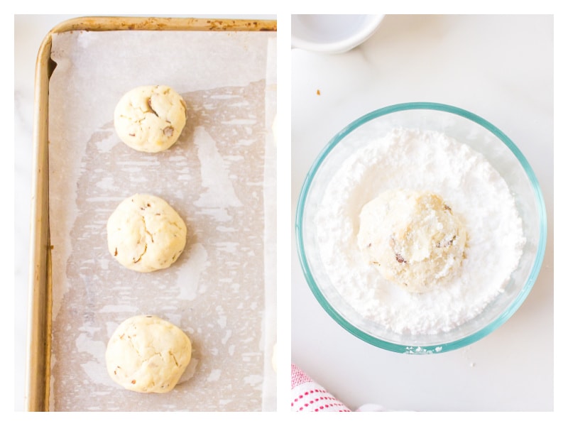 snowball cookies on a baking sheet with one rolled in a bowl of powdered sugar