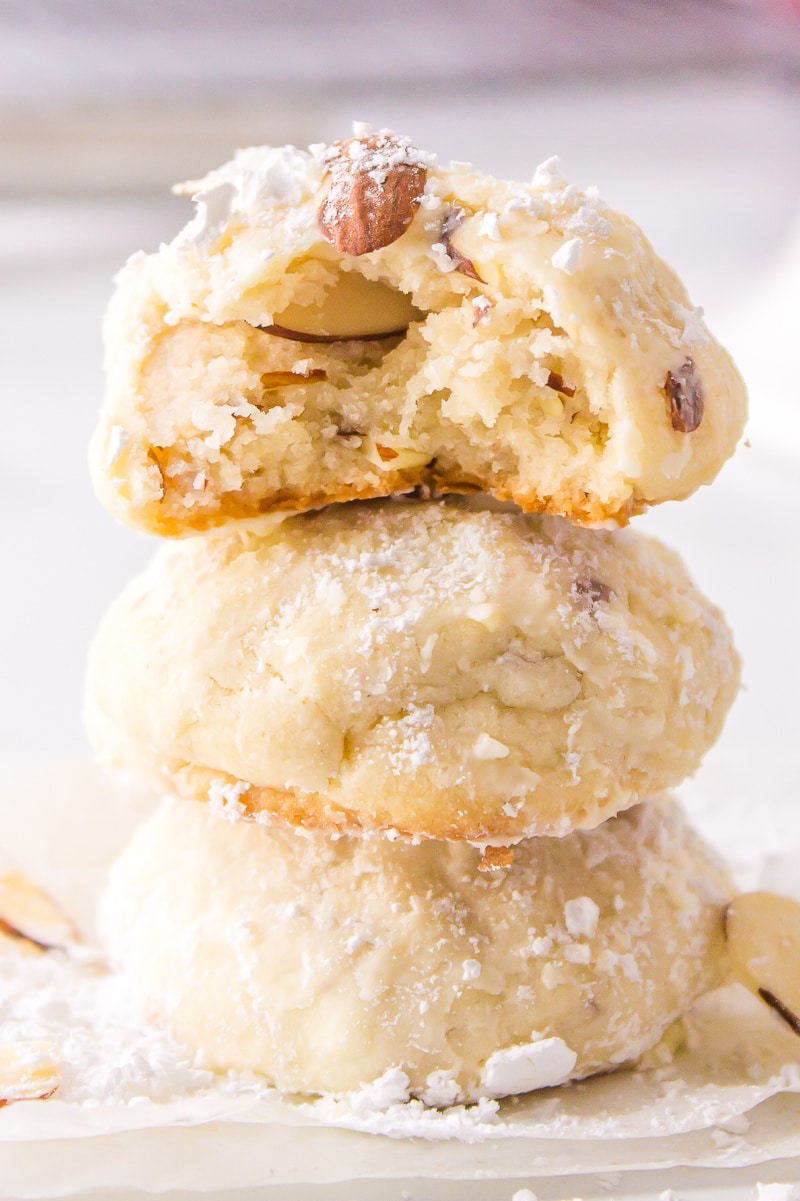 three stacked snowball cookies one with a bite out of it