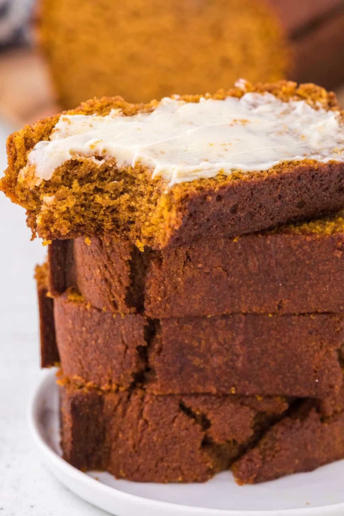 This moist Whole Wheat Pumpkin Bread is made with olive oil, pumpkin puree, whole wheat flour, cinnamon, nutmeg and warm fall spices. It's an easy pumpkin bread recipe for breakfast, snacking, freezing or fall gifting. whole wheat pumpkin bread slices buttered