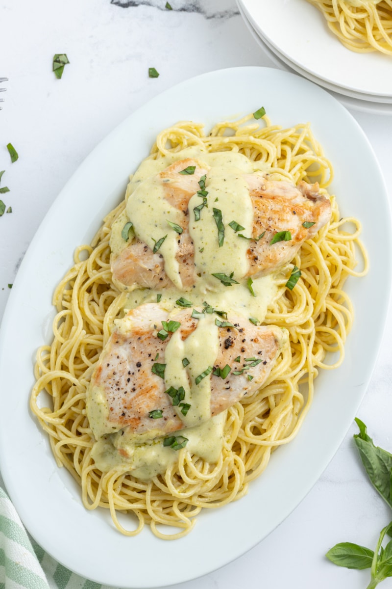 platter of creamy pesto chicken over noodles