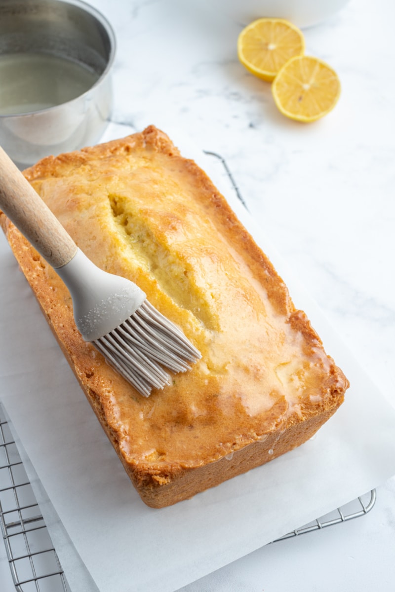 brushing citrus juice onto lemon lime pound cake