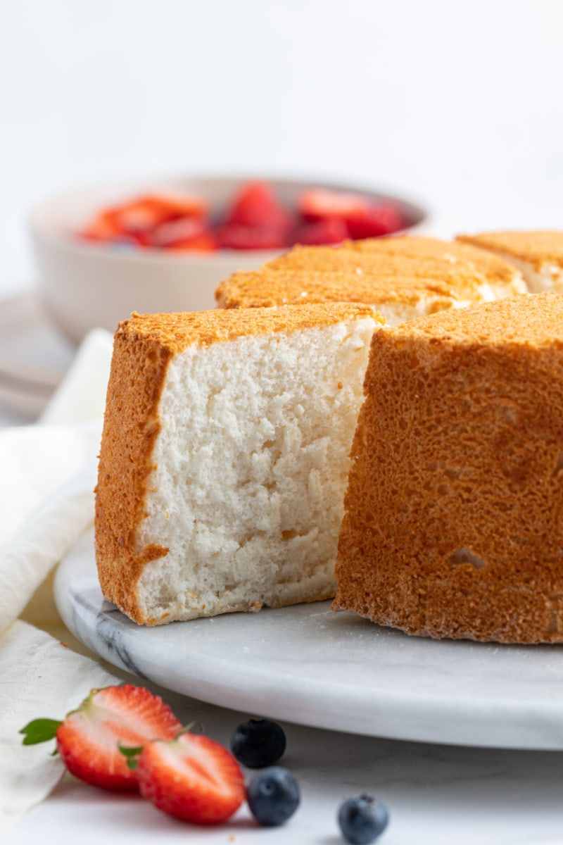 slice of angel food cake being pulled out of the whole cake