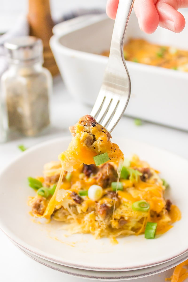 fork digging into piece of brunch casserole on plate