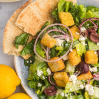 plate of greek caesar salad with pita bread