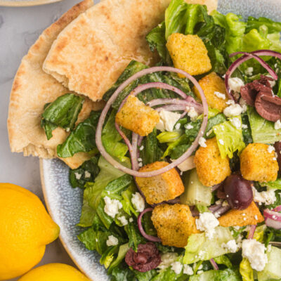 plate of greek caesar salad with pita bread