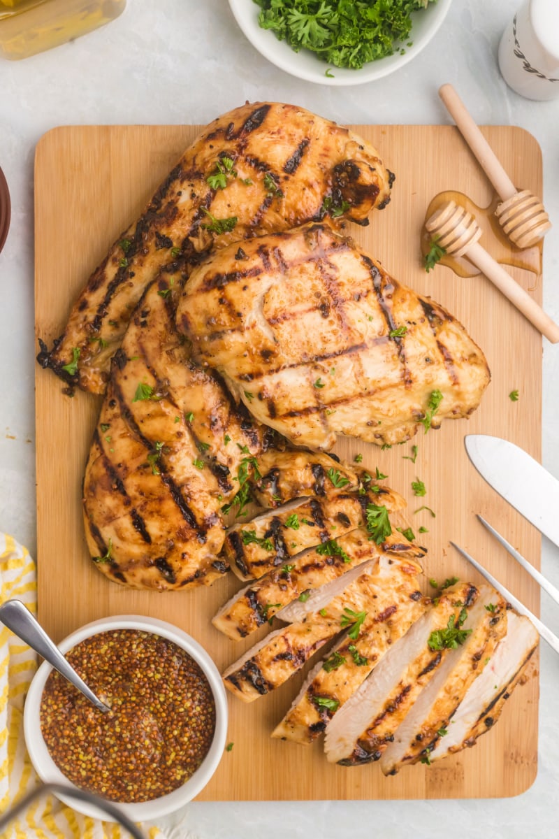 honey mustard grilled chicken on a cutting board some sliced