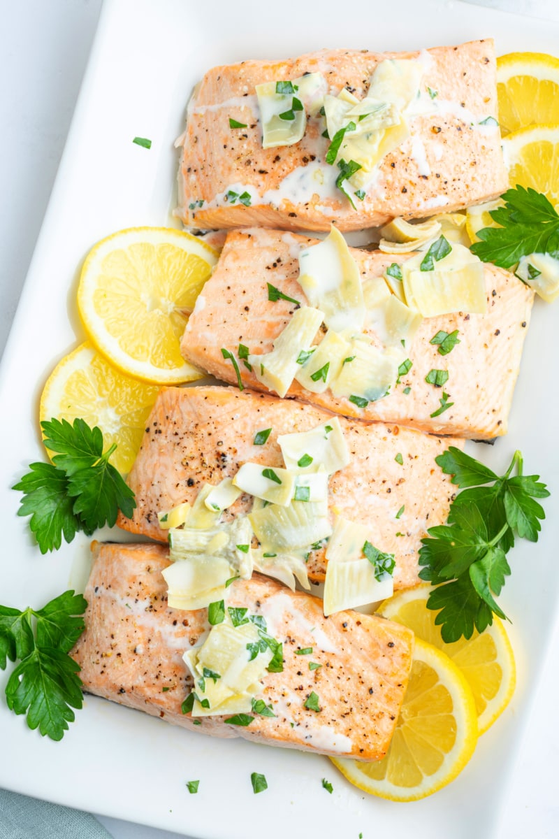 air fryer salmon fillets topped with chardonnay butter sauce and lemon slices