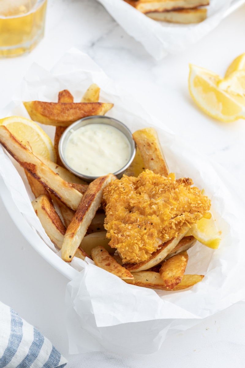 baked fish and chips in a basket with sauce