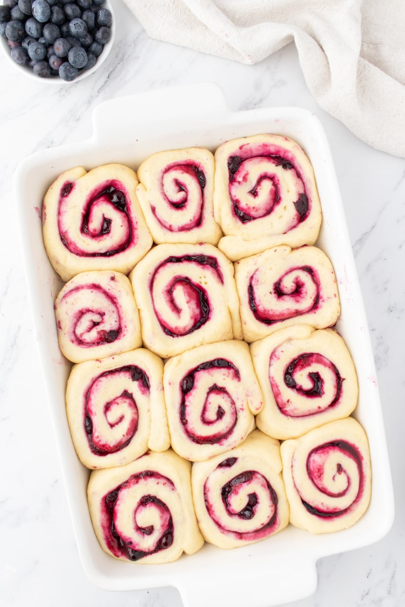 blueberry sweet rolls in a pan ready for oven