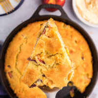 slice of peach cornbread above cast iron cornbread