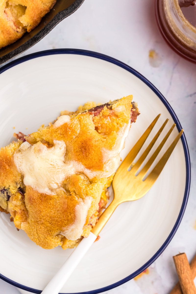 slice of cast iron peach cornbread on plate with fork