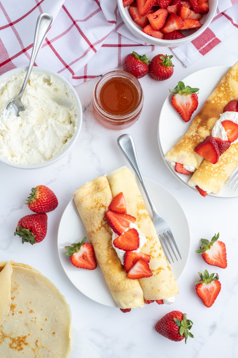 overhead shot of plates of strawberry cream cheese crepes
