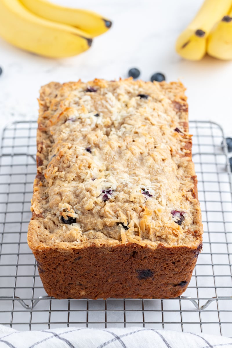 loaf of coconut blueberry banana bread on a cooling rack