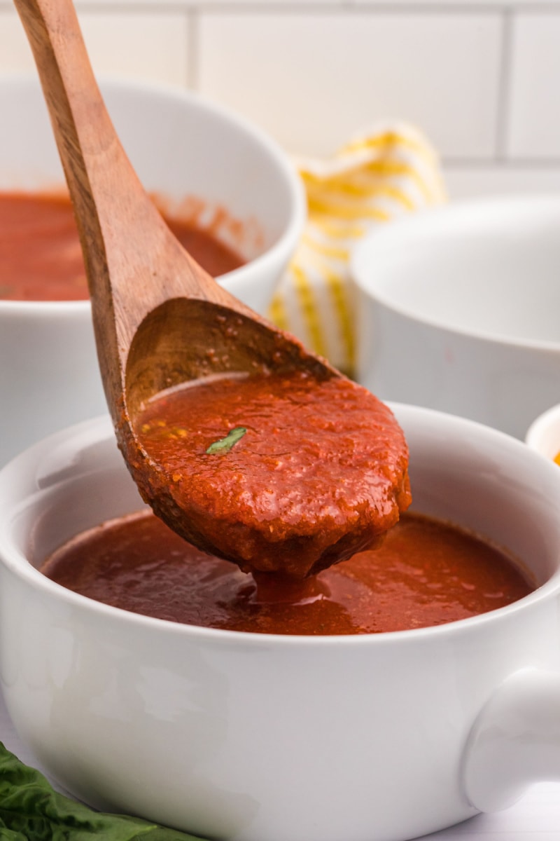 spooning out chilled tomato soup out of bowl