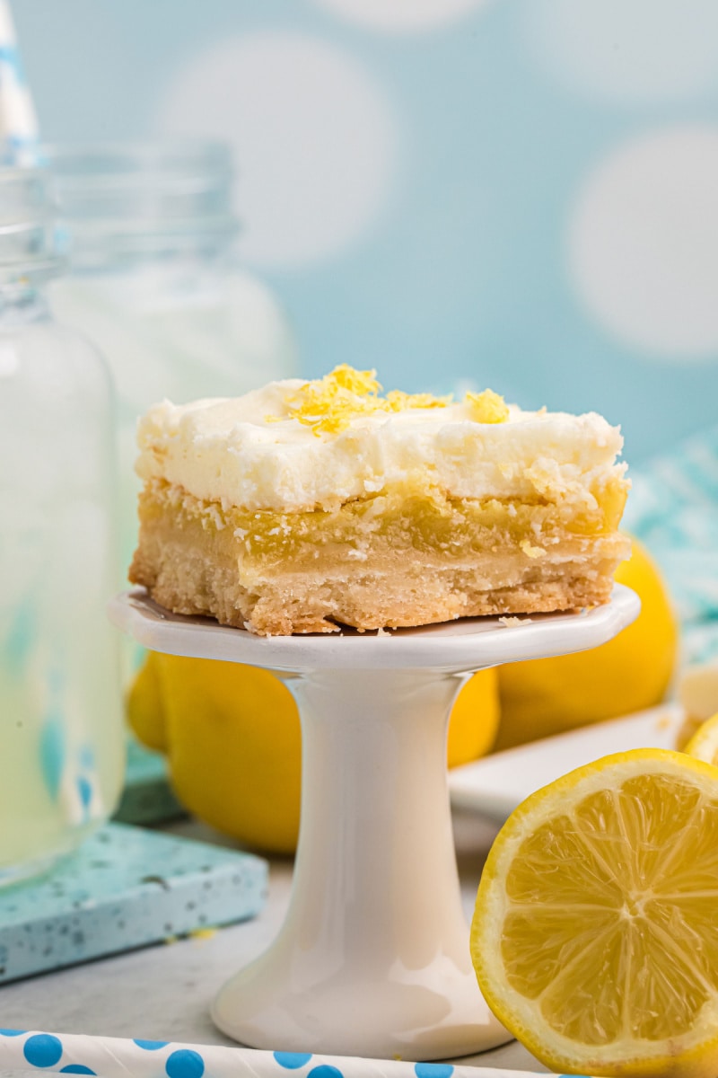 frosted lemon bar on a dessert stand
