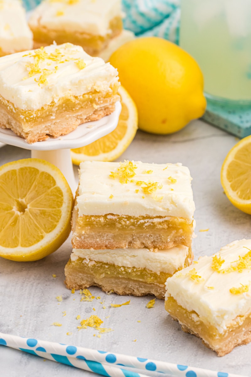 frosted lemon bars with fresh lemons displayed