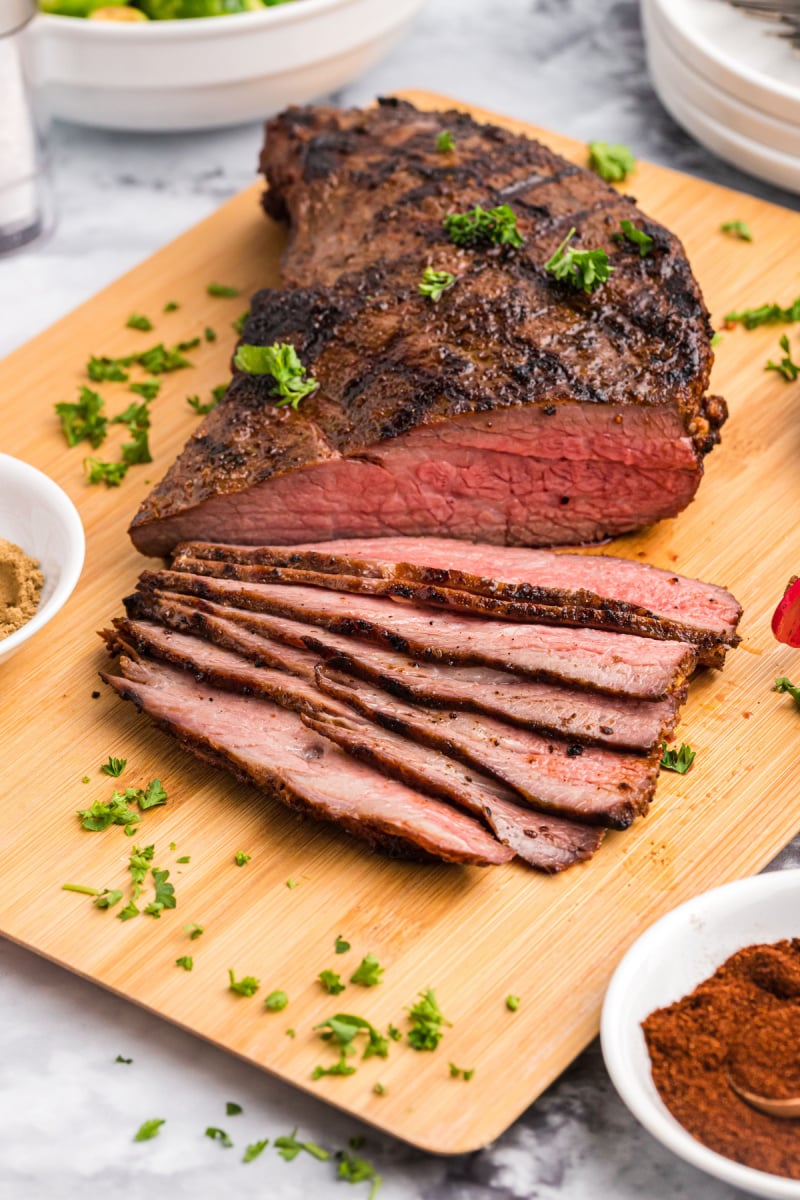 grilled trip tip on cutting board part of it sliced