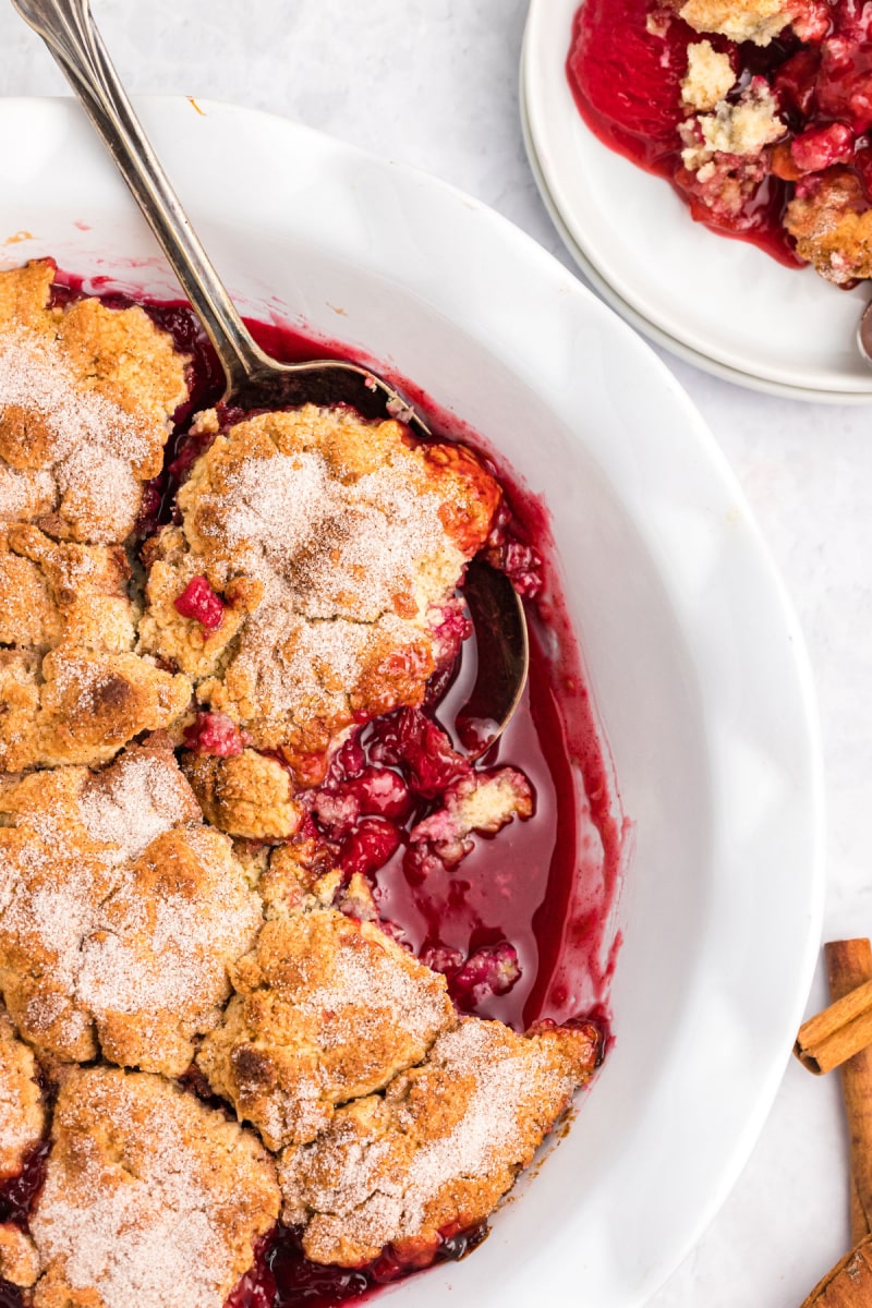 plum cobbler in dish with spoon