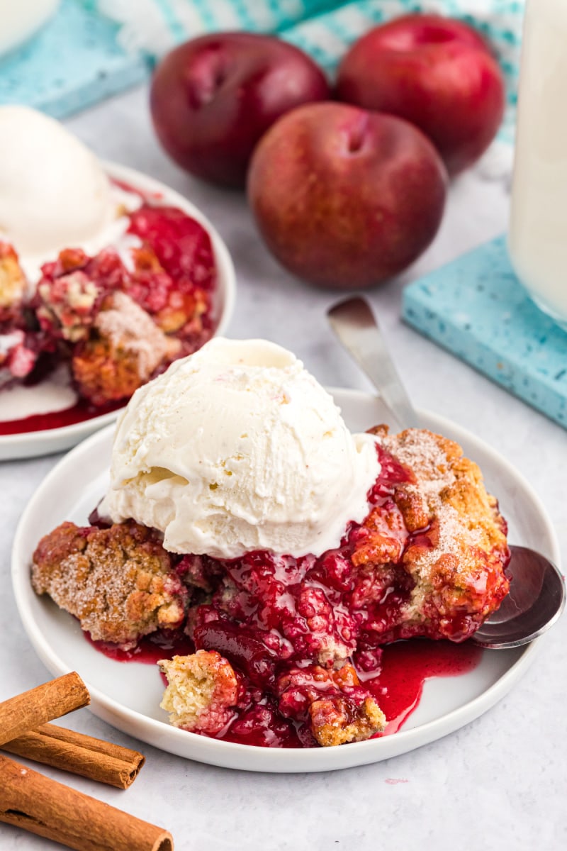 serving of plum cobbler on plate with ice cream
