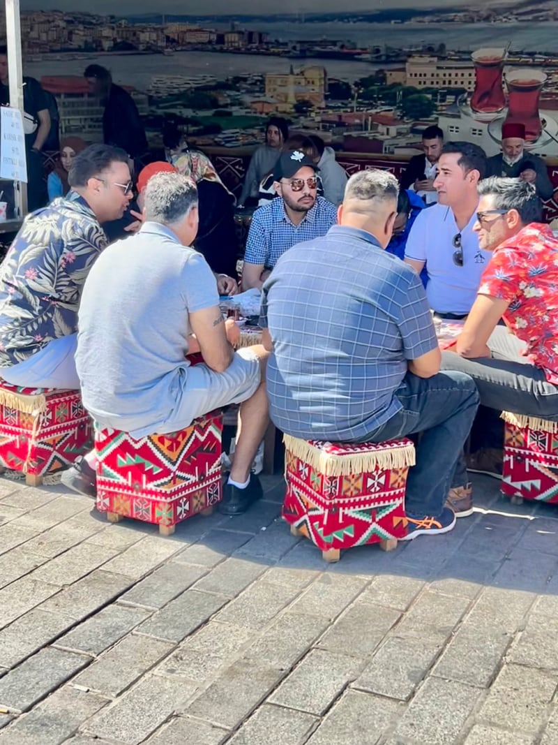 turkey men sitting on little stools