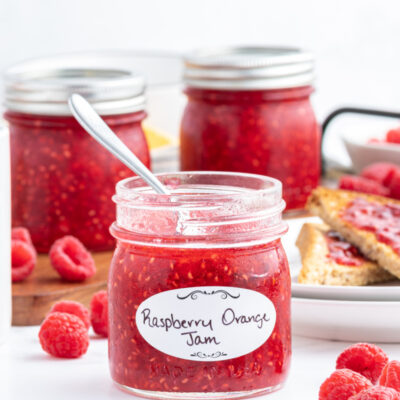 spoon inside jar of raspberry orange freezer jam