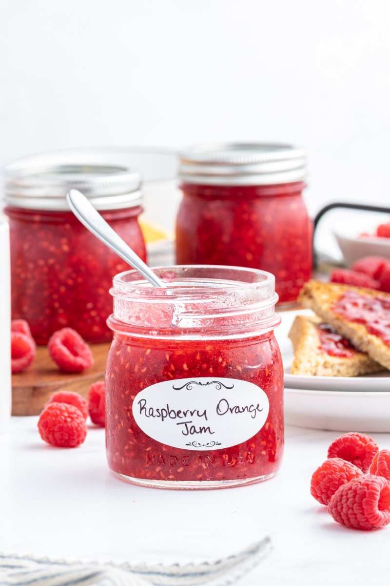 spoon inside jar of raspberry orange freezer jam