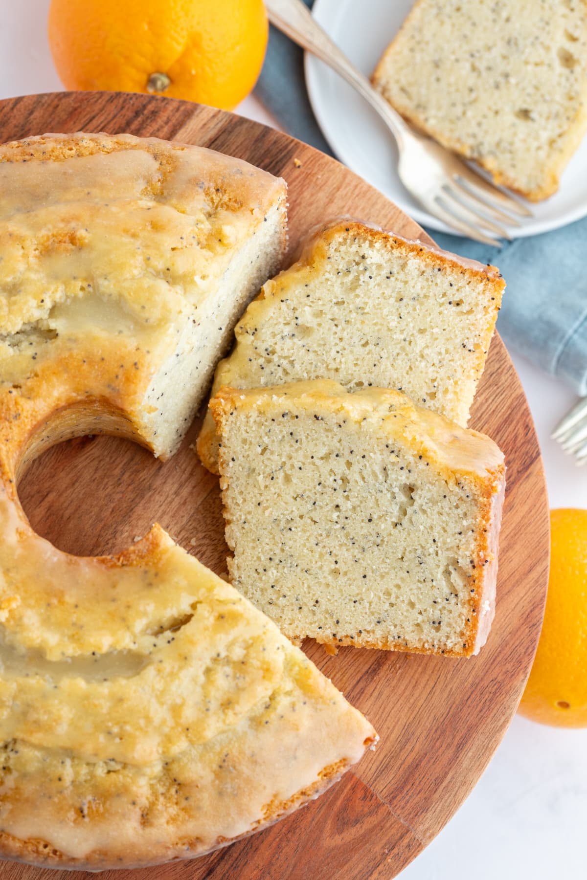 almond orange poppy seed cake on serving board with slices cut out