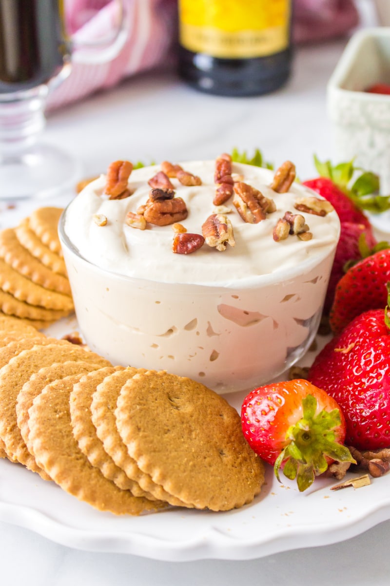 kahlua dip displayed in glass bowl with strawberries and cookies