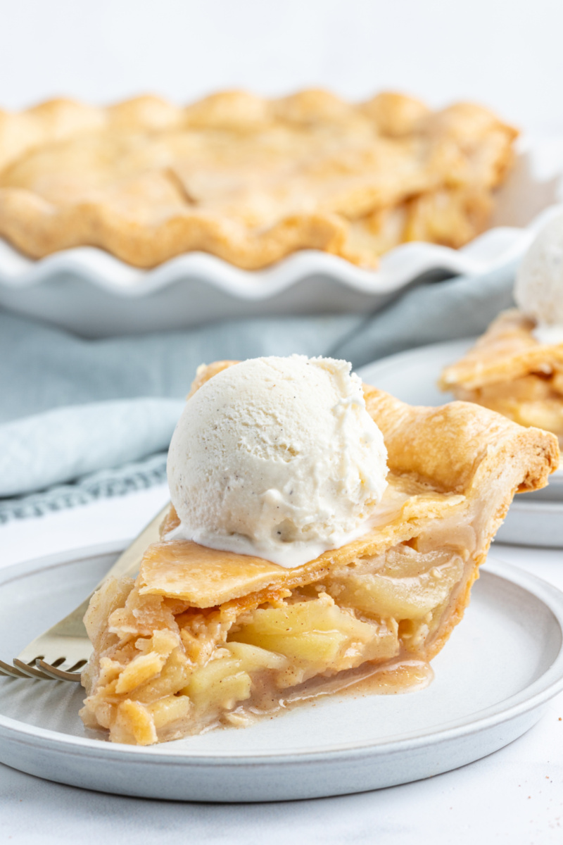 slice of maple apple pie on a plate with ice cream