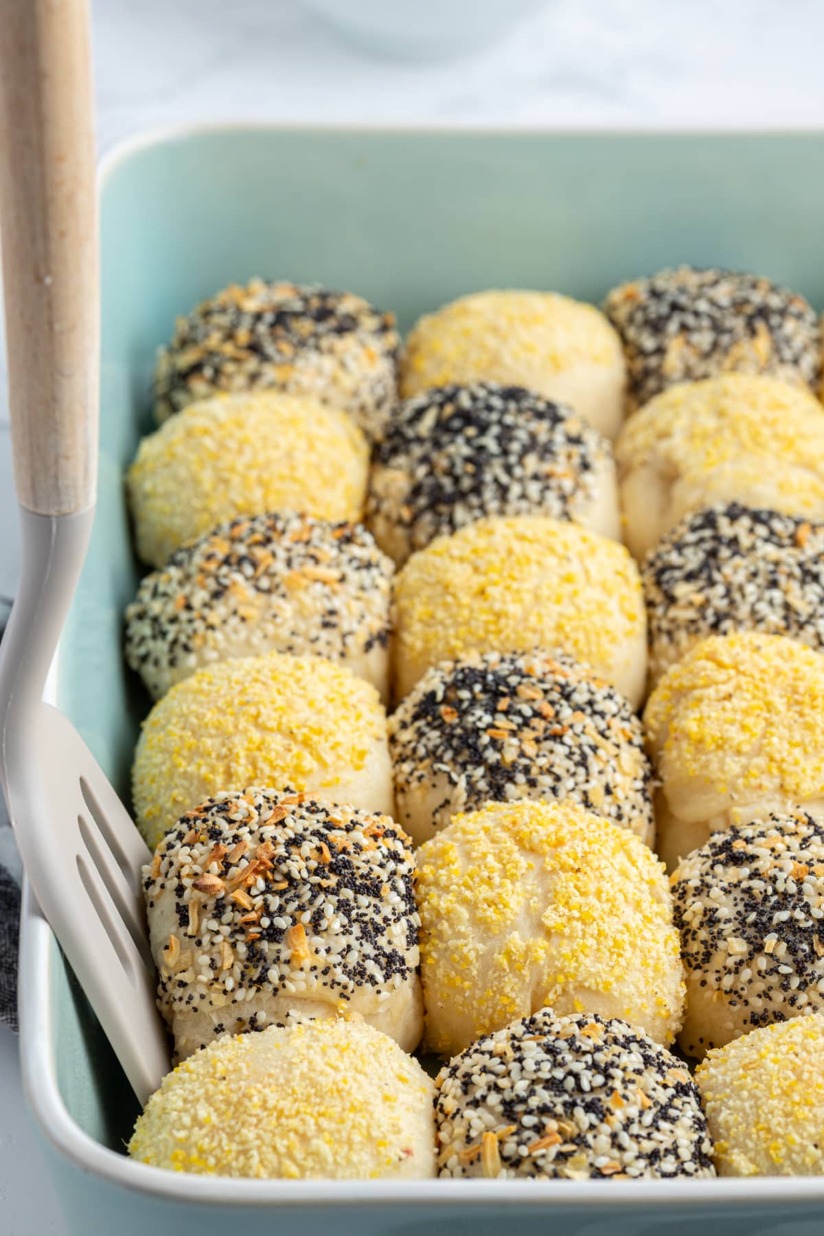 spatula taking out checkerboard dinner roll in baking dish